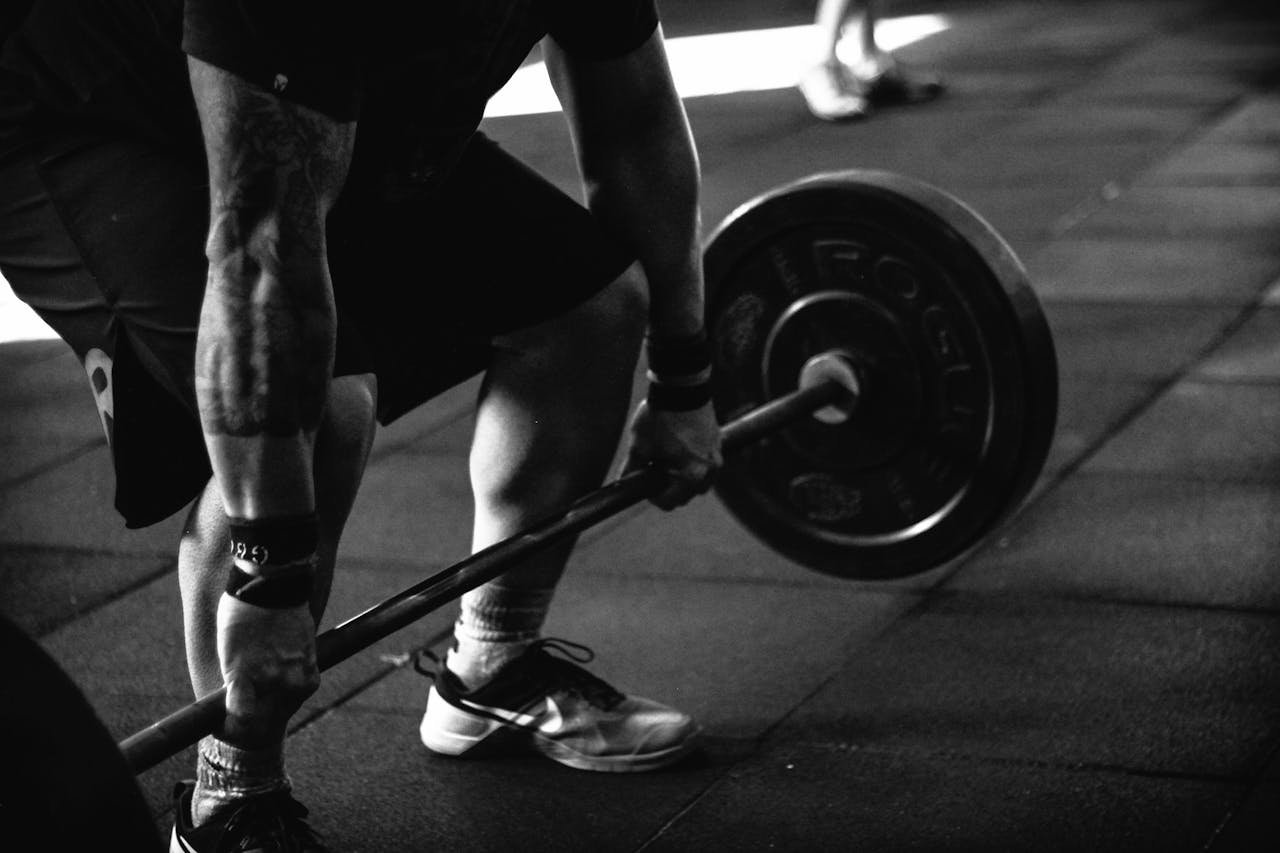Bruno Lozano Rebel. A powerful black and white image of a man deadlifting in a gym, showcasing strength and fitness.